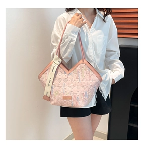 Detail of pink quilted tote bag with diamond stitching and decorative branding strap