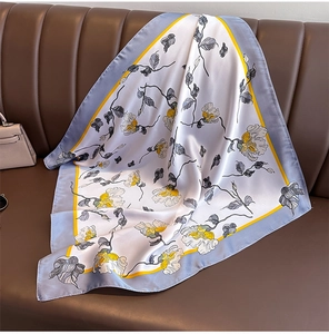 Carré en satin à imprimé floral disposé sur un canapé en cuir avec décor de luxe
