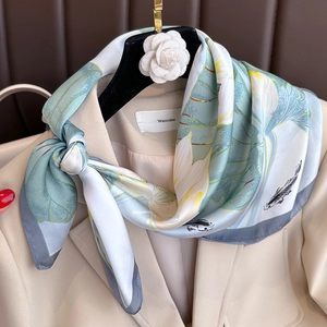 Elegant silk scarf with lotus and koi fish patterns on beige suit collar