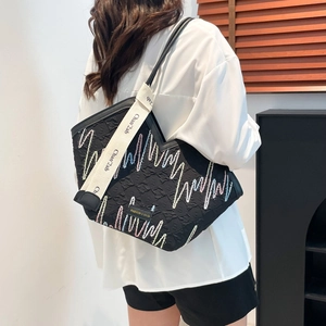 Large black commute tote bag with colorful wave embroidery and woven shoulder strap