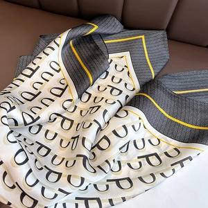 Close-up of silk scarf showing geometric herringbone patterns and yellow border detail