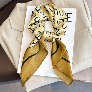 Elegant yellow silk scarf with letter prints and herringbone border on chic background