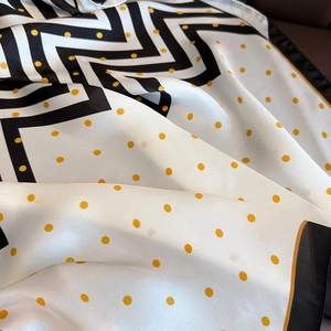 Gros plan d'un foulard carré à pois avec motif géométrique et texture satinée lisse