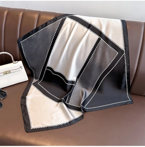 Vista dettagliata di un foulard in seta quadrato con motivo geometrico bianco e nero