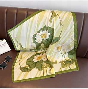 Detailed texture of a vintage silk scarf with elegant lotus print on a leather surface
