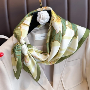 Elegant vintage lotus pattern silk scarf styled as a shawl over a beige blazer jacket