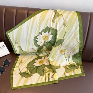 Vintage lotus pattern silk scarf displayed on leather sofa with elegant fashion accessories