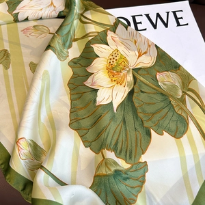 Macro shot of silk scarf showing vintage lotus flower pattern and glossy fabric texture