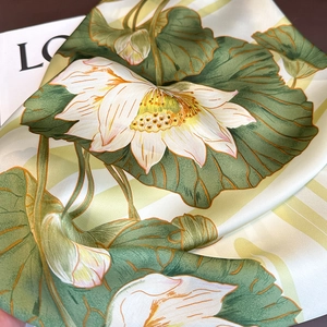 Detailed close-up showing silk fabric texture and elegant lotus flower pattern print