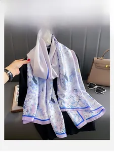 Détail d'un foulard en soie lavande à fleurs drapé sur une tenue noire élégante