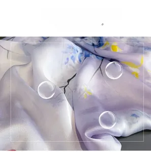 Détail du tissu d'un foulard en soie lavande avec motif floral et texture lisse