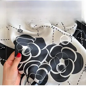 Detail of silk-like camellia scarf showing soft fabric texture and black-white pattern