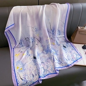 Écharpe en soie à motif floral lilas et bordure bleu foncé sur canapé chic