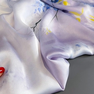 Gros plan d'un foulard en soie violet à fleurs avec lustre satiné et drapé élégant