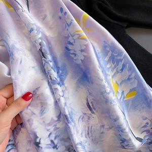Élégant foulard en soie violette avec motif floral et texture satinée lisse