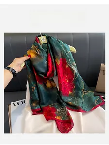 Detail of silk-like scarf featuring deep green satin with red peony floral patterns