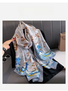 Detailed view of elegant satin scarf featuring dark brown maple leaves and ocean wave patterns