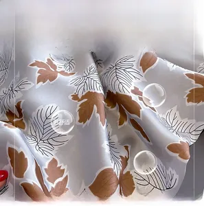 Detailed close-up of light blue silk-like fabric featuring elegant brown leaf prints