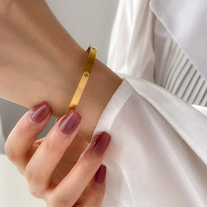 Elegant gold honeycomb open bangle with star engraving and crystals on model's wrist