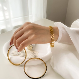 Gold hollow honeycomb bracelet and minimalist bangle set shown in a lifestyle scene