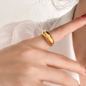 Anello a cupola in oro lucido da donna abbinato a una camicetta bianca a pieghe