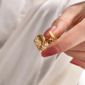 Detail of gold geometric hollow lattice ring with a smooth circular sequin accent