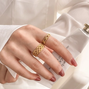 Detail of gold hollow geometric woven rings worn with elegant white silk blouse