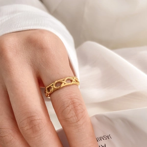 Close-up of golden hollow woven mesh ring with geometric diamond lace texture