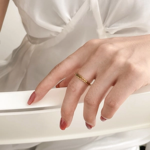 Bague dorée minimaliste avec triangle géométrique ajouré portée avec élégance