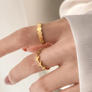 Detail of gold-plated rings set featuring olive leaf design and matte circular textures