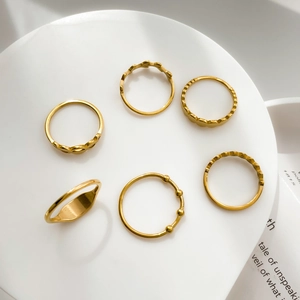 Detailed view of 6-piece golden stacking ring set featuring geometric patterns and beads