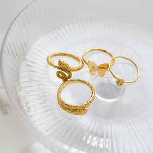 Four-piece gold vintage punk ring set featuring snakes, butterfly and dollar sign designs