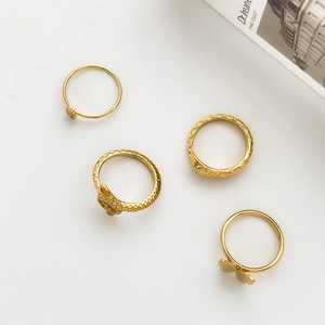 Detailed view of four vintage gold punk rings including snake and butterfly designs