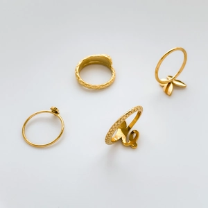 Detail view of a 4-piece vintage punk gold ring set featuring snake and butterfly designs
