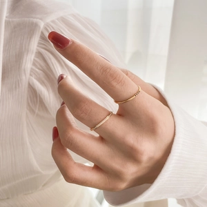 Close-up of elegant gold stacked rings with micro-set crystals on model hand