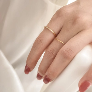Detail of elegant gold stackable rings with sparkling crystals on soft white fabric