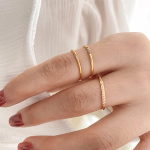 Macro view of three stacked gold-plated rings with black and white zircon stone details