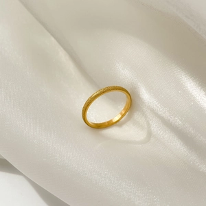 Gros plan sur l'élégante bague en or mat avec une finition brossée sur un tissu en soie