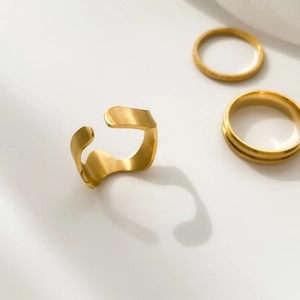 Gros plan sur la texture dorée mate brossée de la bague réglable au design minimaliste