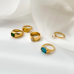 Set of five gold plated rings featuring emerald, yellow, blue, and clear zircon stones