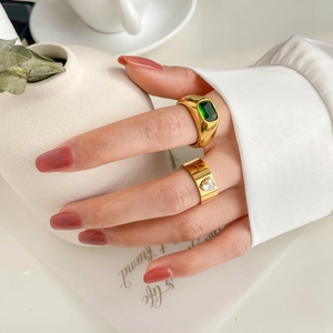 Gold-plated rings with rectangular green gem and heart zircon, shown stacked on hand