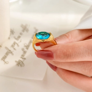Macro detail of a large oval blue zircon gemstone set in a gold-plated titanium ring