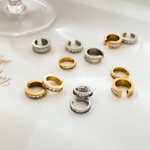 Dettaglio di ear cuff a forma di C in oro e argento con pavé di zirconi cubici