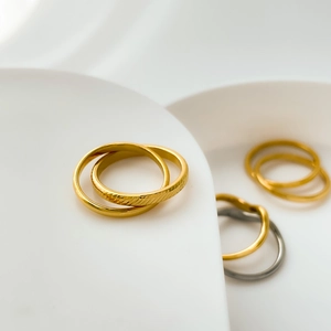 Detailed close-up of double-linked golden rings with elegant textured engraving on metal