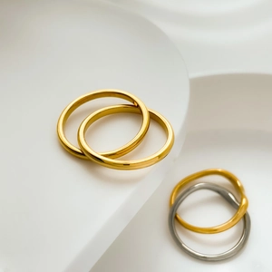 Close-up of minimalist interlocking gold and silver rings with high-polish smooth finish
