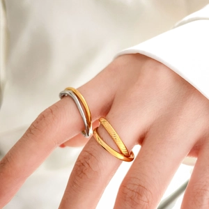 Close-up of interlocking minimalist rings with polished finish and textured engraving details