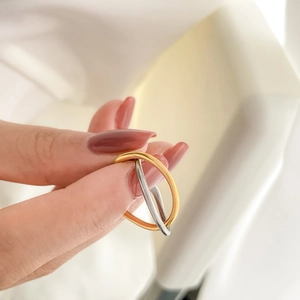 Macro shot of interlocking gold and silver rings with polished mirror finish details