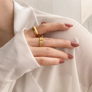 Détail de deux bagues dorées avec motif étoile et zircons sur la main d'un mannequin