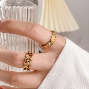 Bagues dorées de luxe avec étoile en nacre et design alvéolé sur une main de femme