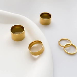 Detailed view of 5-piece minimalist wide and thin polished gold rings set for layering